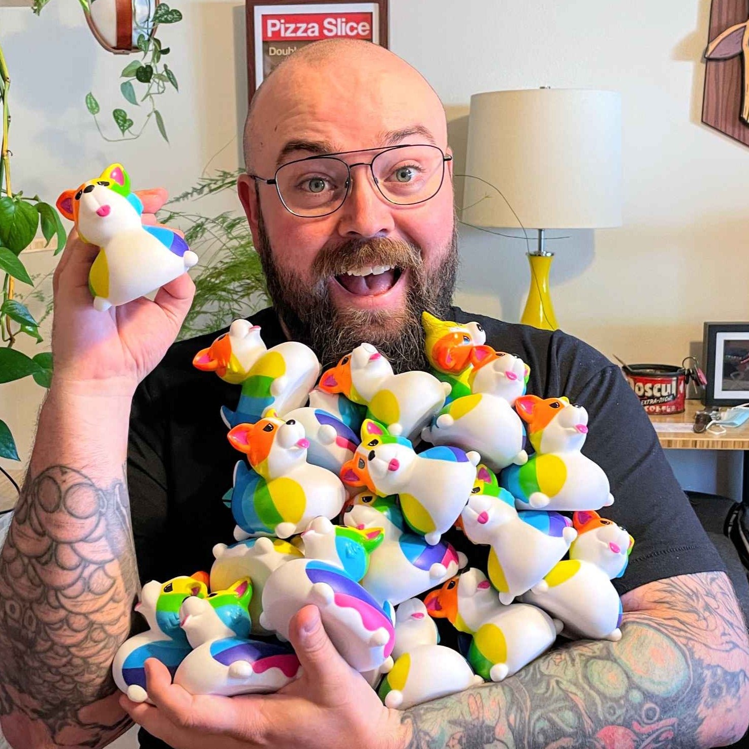 Jason holding an armload of corgi ducks and looking very excited about it